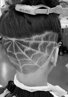 Freehand spiderweb hair design carved into a fade at EP Central Barbershop